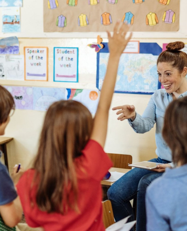 Foto van 6 schoolkinderen en een juf in een klaslokaal