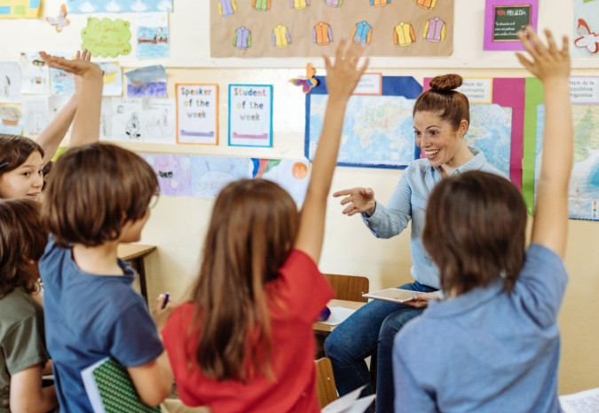 Foto van 6 schoolkinderen en een juf in een klaslokaal
