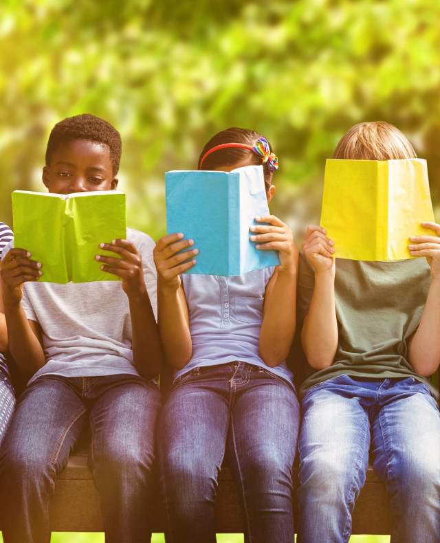 Afbeelding van 5 kinderen op een houten bankje die ieder een boek lezen