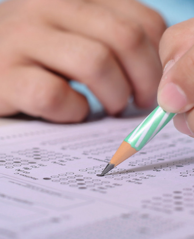 Afbeelding kinderhanden die multiple choice toets maken met potlood